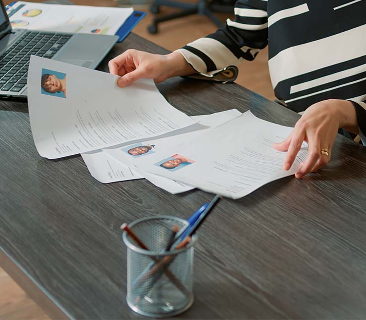 Recruiter reviewing IT candidate profiles on a laptop for talent sourcing.