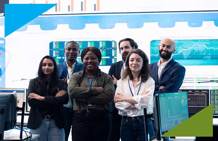 Diverse cybersecurity team standing confidently in a financial operations center, representing VFINDIT’s cybersecurity staffing for banks and data protection services.
